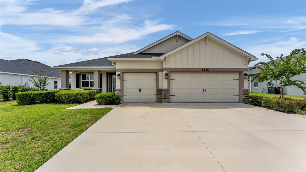 A single-story suburban house with a two-car garage and a concrete driveway — 6686 TREYMONT DRIVE, LAKELAND, FL