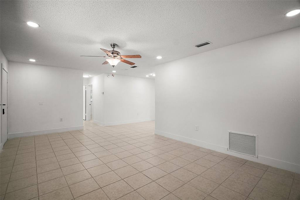 An empty room with white walls, a ceiling fan, and light-colored tile flooring — 14884 SW 35TH CIRCLE, OCALA, FL