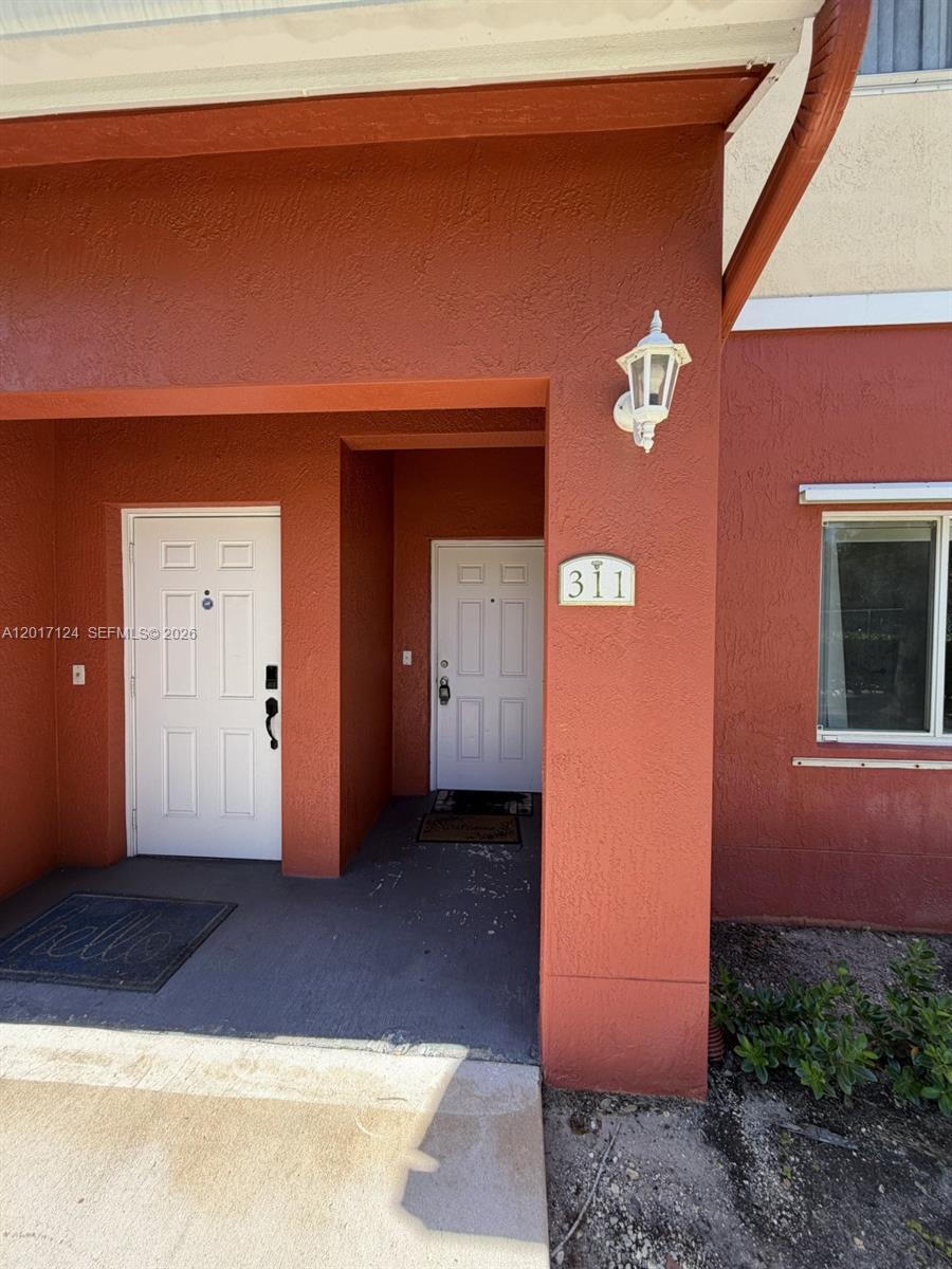 The exterior view shows two white front doors on a terracotta-colored porch with stucco walls — 3335 Palomino Dr # 3, Davie FL 33024, DAVIE, FL