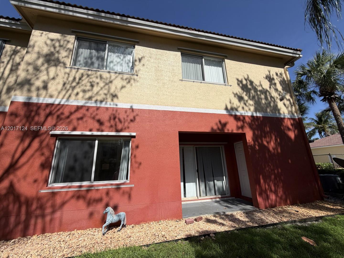 The exterior of a two-story house features a red lower level and beige upper level — 3335 Palomino Dr # 3, Davie FL 33024, DAVIE, FL
