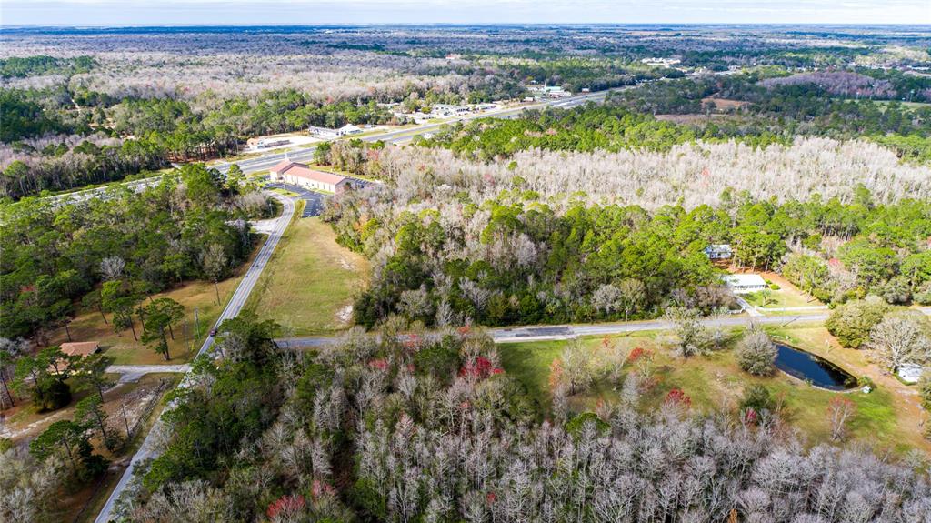 An aerial view shows a rural landscape with a road, a church, and a small pond — 4925 S MORNINGSIDE TERRACE, HOMOSASSA, FL