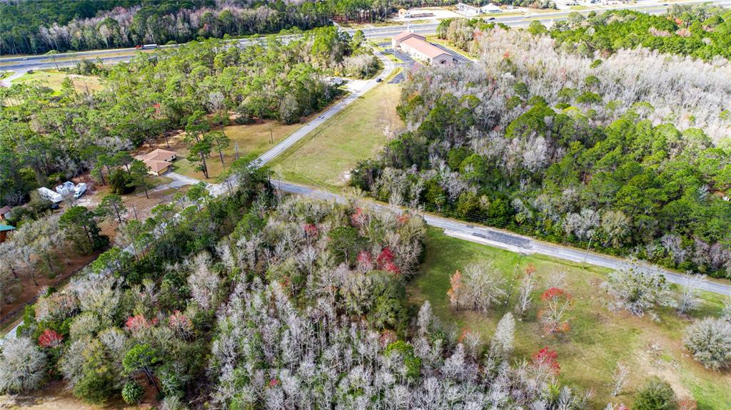 An aerial view shows a wooded lot bordered by two intersecting paved roads — 4925 S MORNINGSIDE TERRACE, HOMOSASSA, FL