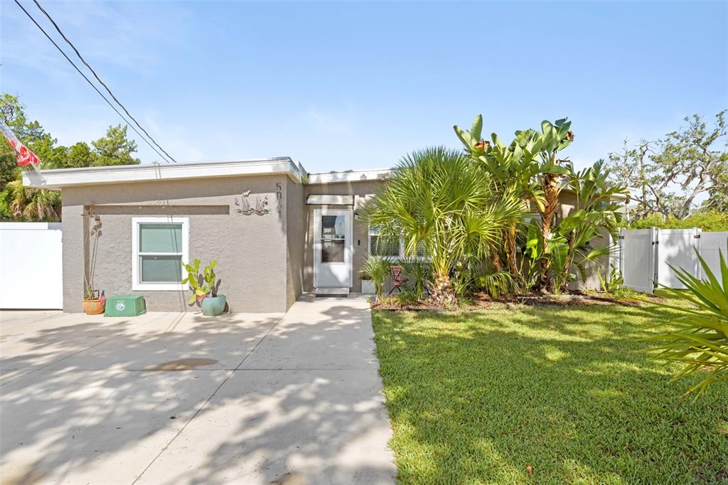 A single-story house with a concrete driveway, a front lawn, and tropical landscaping — 5041 MAPLEWOOD, HERNANDO BEACH, FL