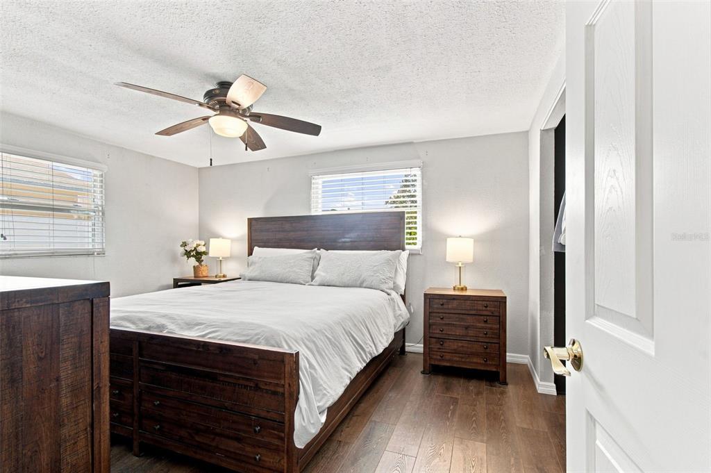 A bedroom features a wooden bed frame, two nightstands, and a ceiling fan — 8467 77TH AVENUE, SEMINOLE, FL