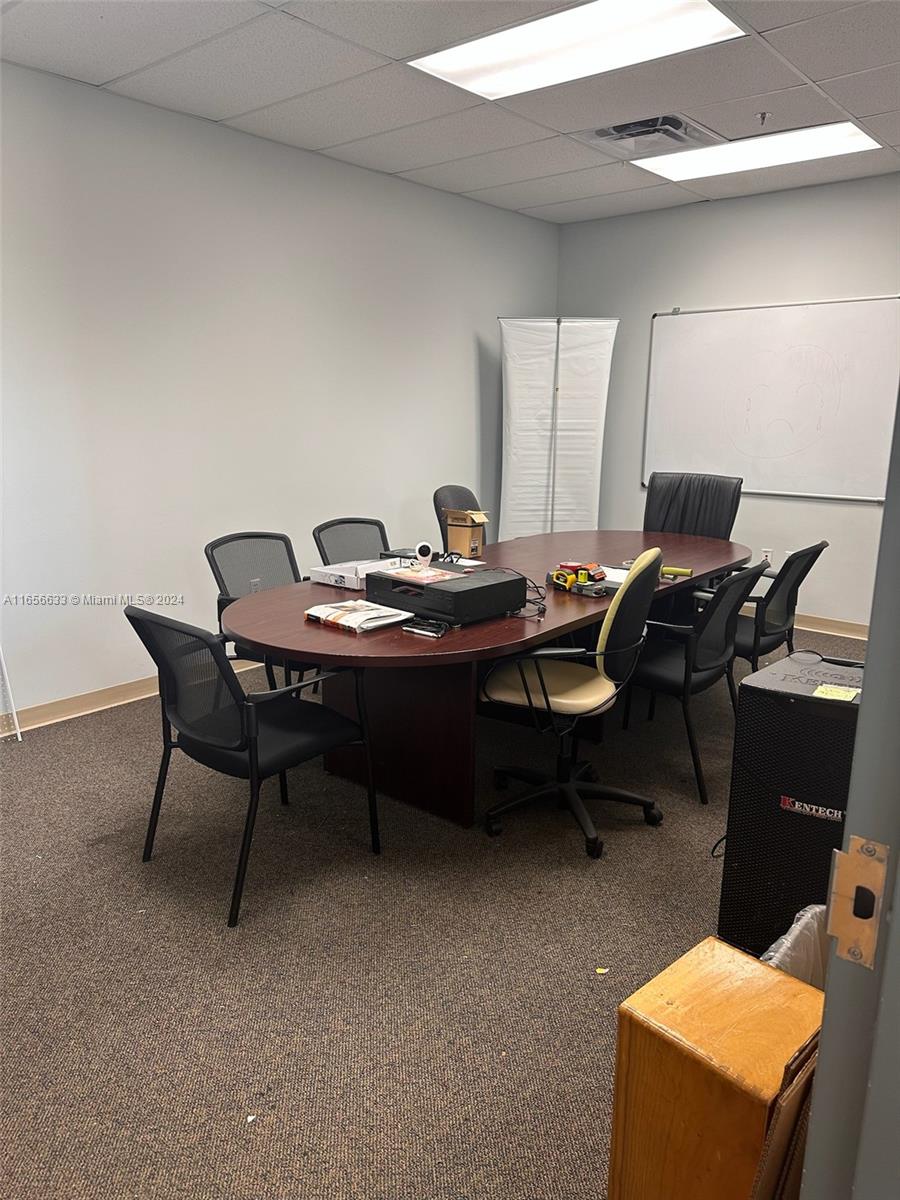 A conference room features a dark wood oval table surrounded by several office chairs — FORT LAUDERDALE, FL