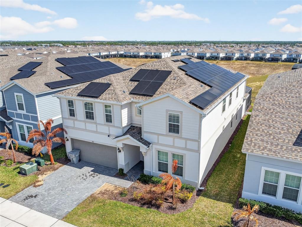 An aerial view of a two-story suburban house with solar panels on the roof — 3711 LANA AVENUE, DAVENPORT, FL