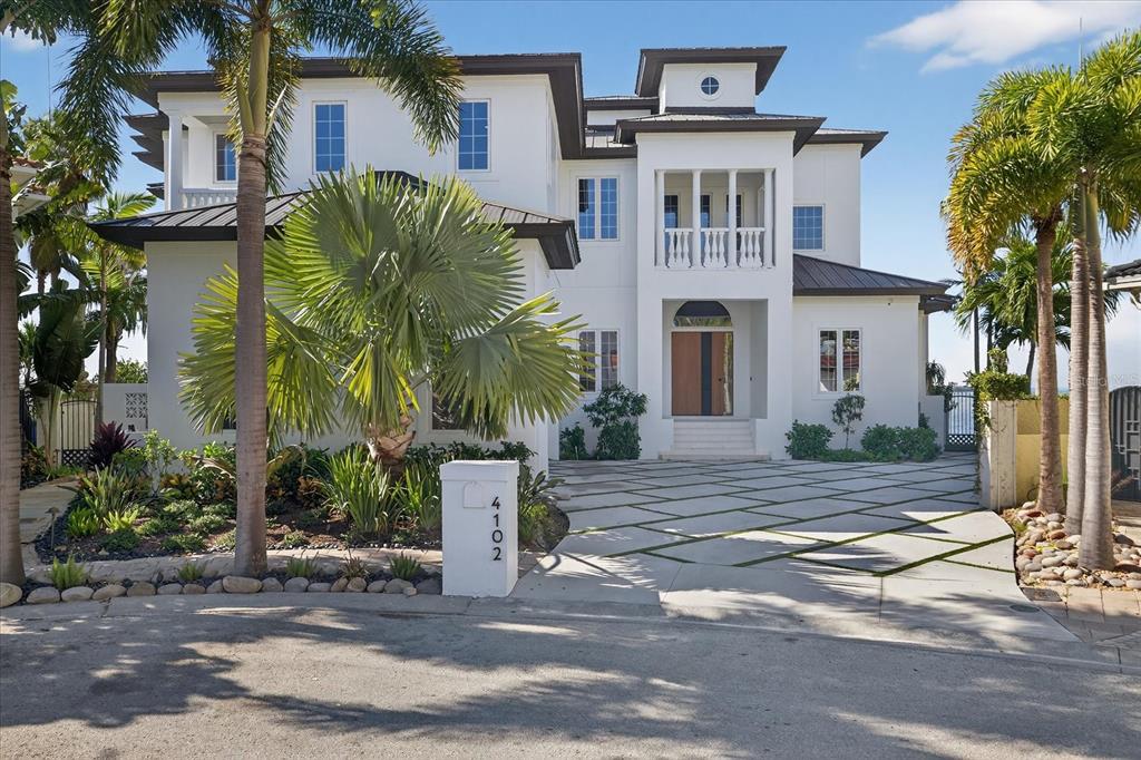 A white multi-story house with a paved driveway and palm trees in the front yard — 4102 CAUSEWAY VISTA DRIVE, TAMPA, FL