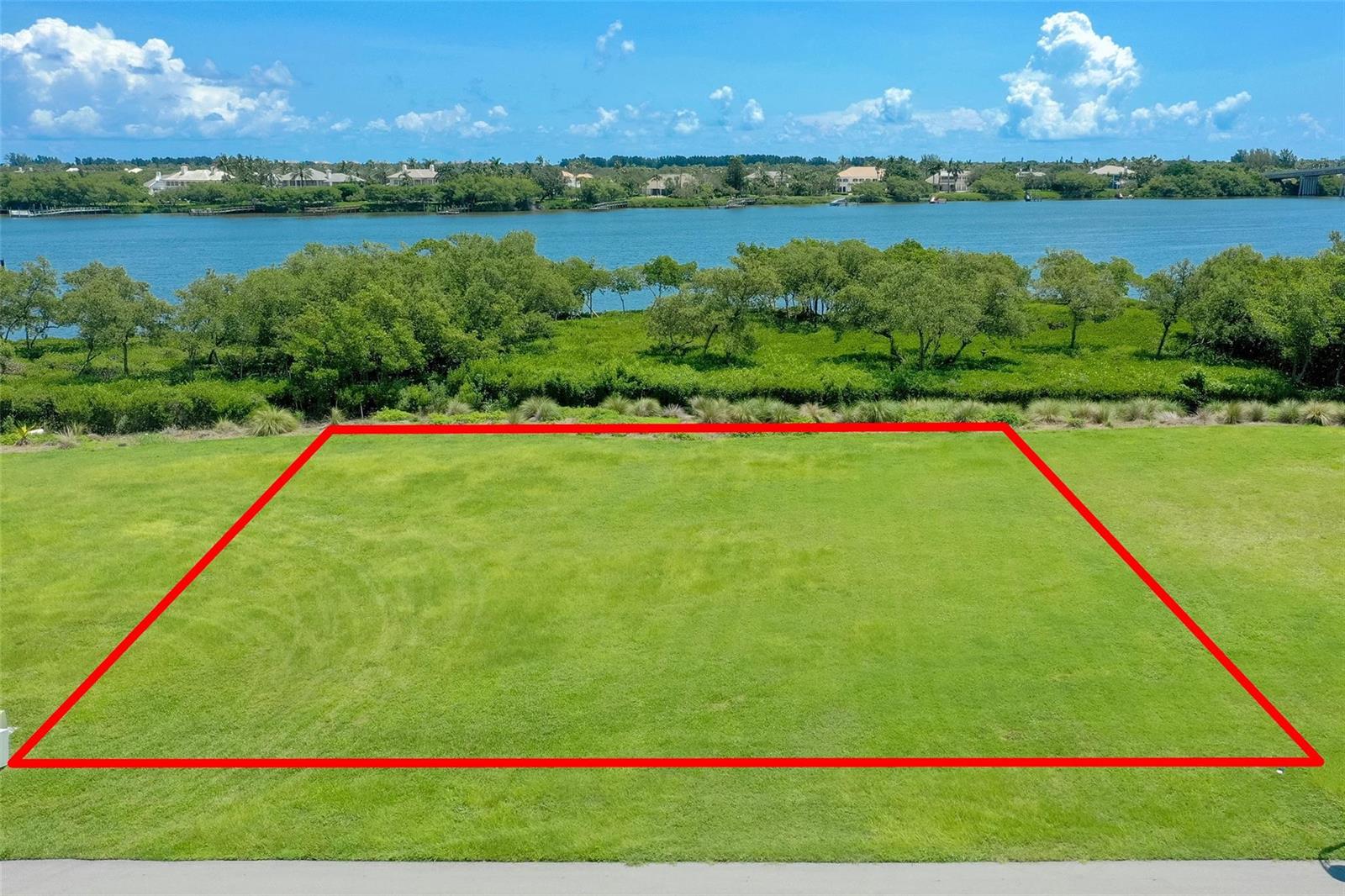 An aerial view shows a rectangular vacant lot outlined in red overlooking a waterway — 9260 E Marsh Island Drive, Vero Beach FL 32963, VERO BEACH, FL