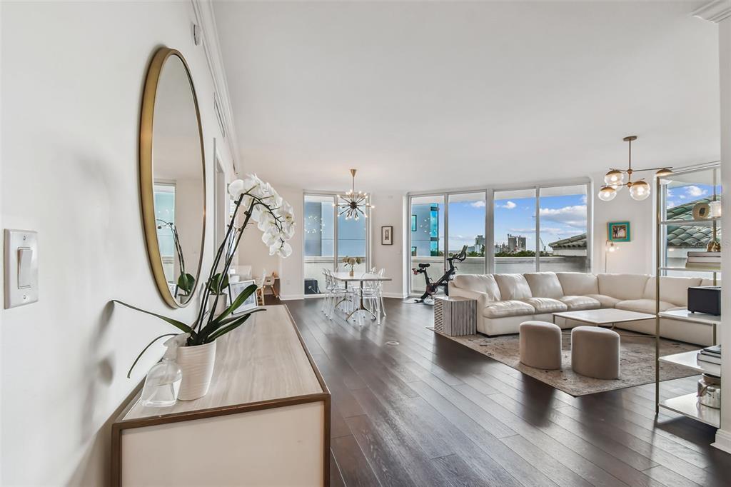 A bright, open-concept living and dining area features dark wood floors and floor-to-ceiling windows — 450 KNIGHTS RUN AVENUE UNIT 502, TAMPA, FL
