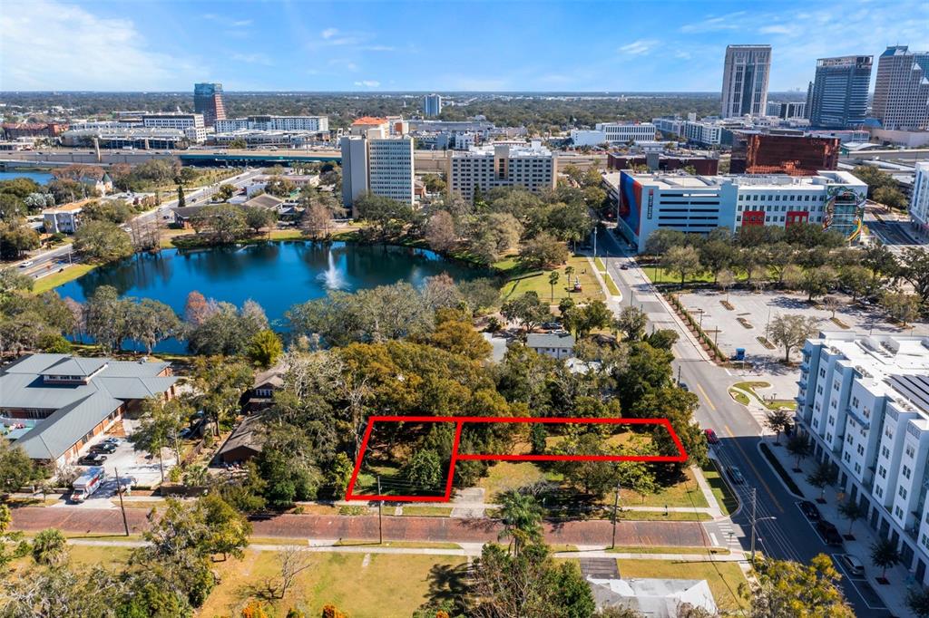 An aerial view shows two adjacent vacant lots outlined in red near a city lake — 623 W CONCORD STREET, ORLANDO, FL