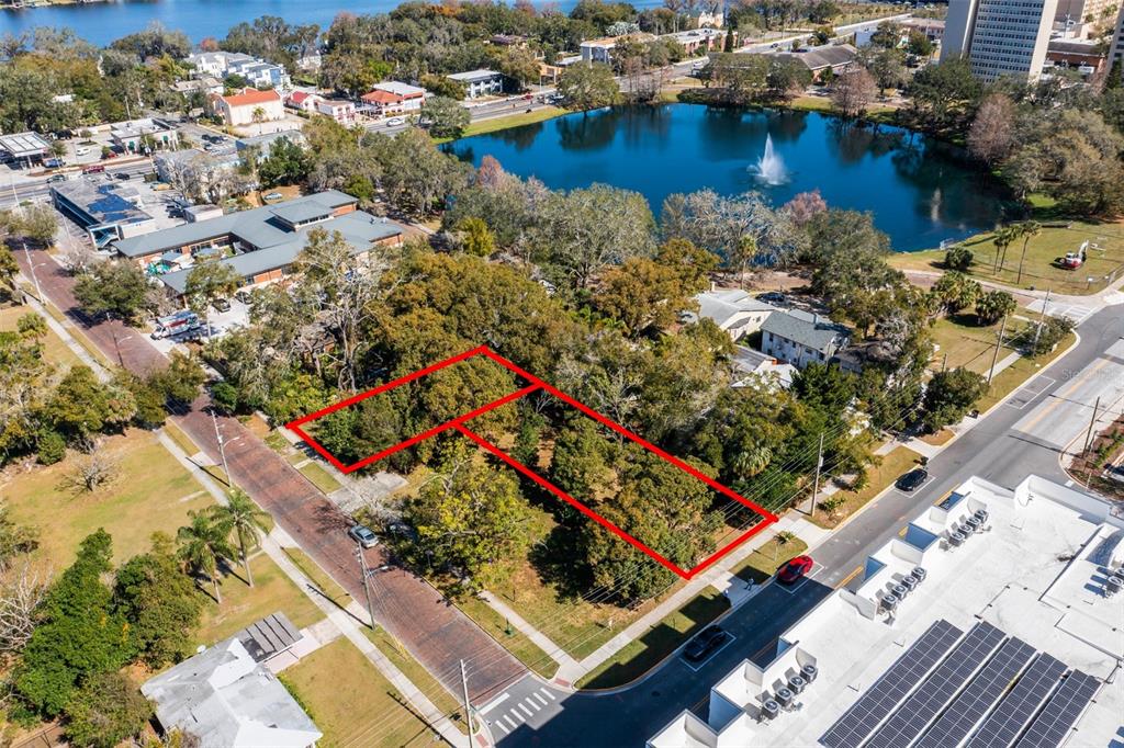 An aerial view shows a vacant, tree-covered lot outlined in red between two paved streets — 623 W CONCORD STREET, ORLANDO, FL