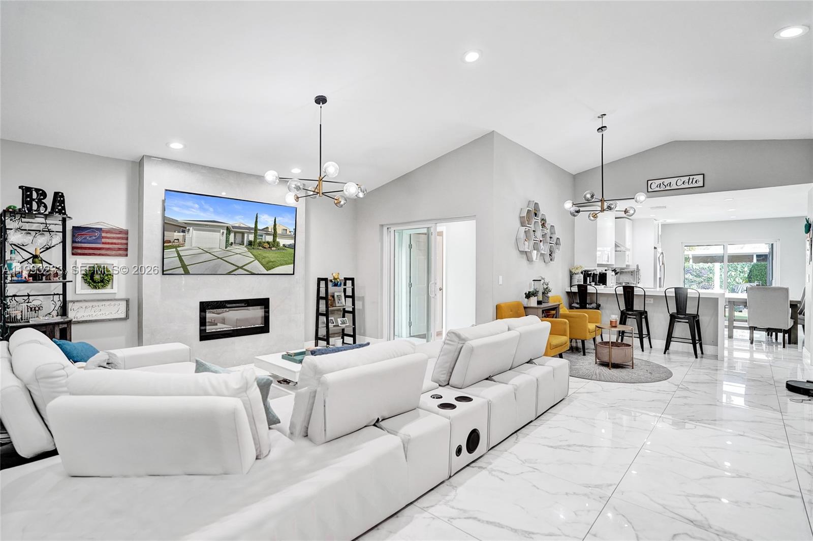 A bright living room features a white sectional sofa, a fireplace, and marble-style flooring — 372 W Riverbend Dr, Sunrise FL 33326, SUNRISE, FL