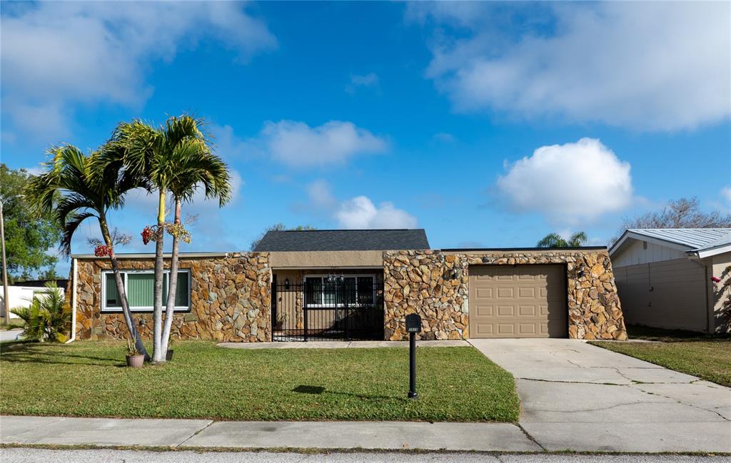 A single-story house features a stone facade, a front lawn, and an attached garage — 3629 HAVEN DRIVE, NEW PORT RICHEY, FL