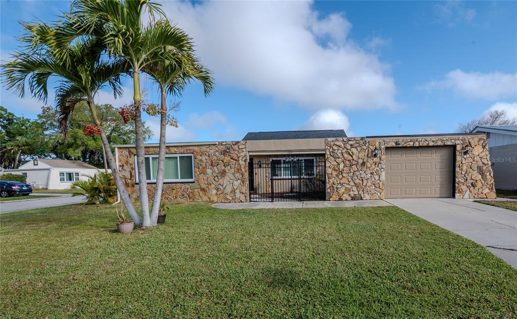 A single-story house with a stone facade, a palm tree, and an attached garage — 3629 HAVEN DRIVE, NEW PORT RICHEY, FL