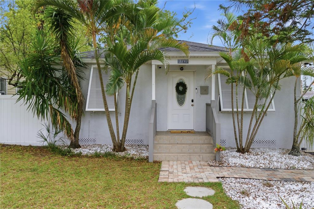 A single-story house with a white door, shutters, and palm trees in the front yard — 2710 16TH AVENUE N, ST PETERSBURG, FL