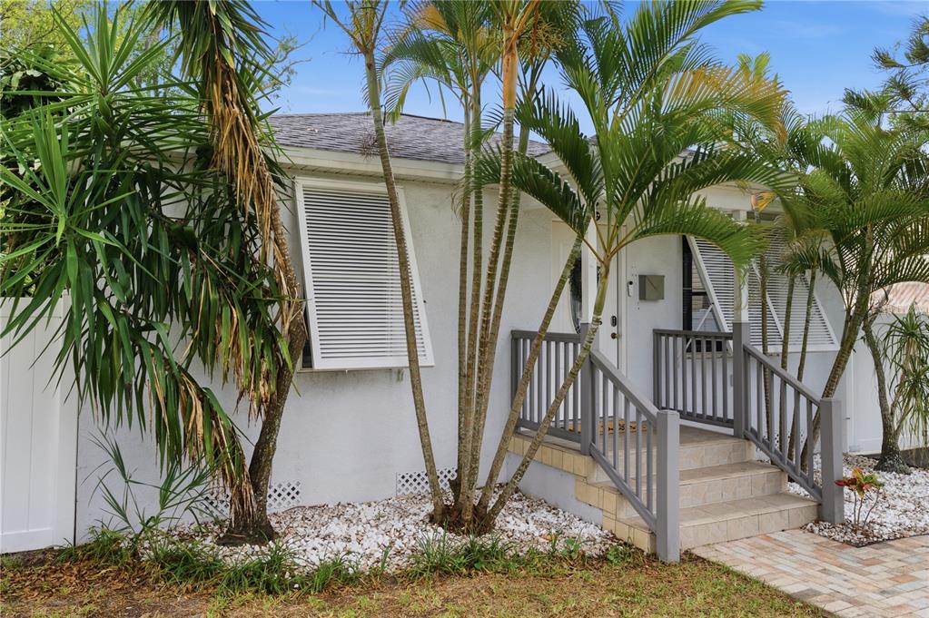 A white house with a gray porch, palm trees, and white shutters in the front yard — 2710 16TH AVENUE N, ST PETERSBURG, FL