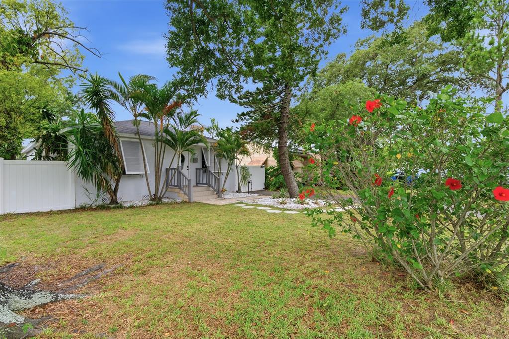 A white house with a front porch and palm trees sits behind a grassy lawn — 2710 16TH AVENUE N, ST PETERSBURG, FL