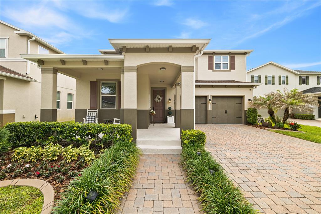 A two-story house with a paved driveway, a covered front porch, and a two-car garage — 11478 WAKEWORTH STREET, ORLANDO, FL
