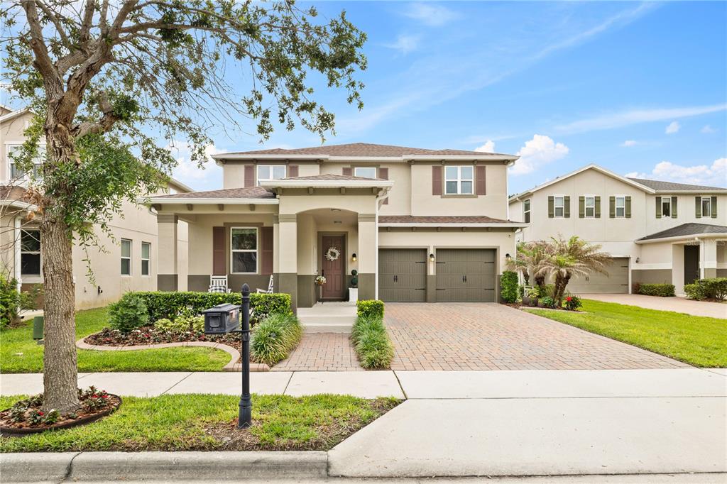 A two-story suburban house with a paved driveway, two-car garage, and a covered front porch — 11478 WAKEWORTH STREET, ORLANDO, FL