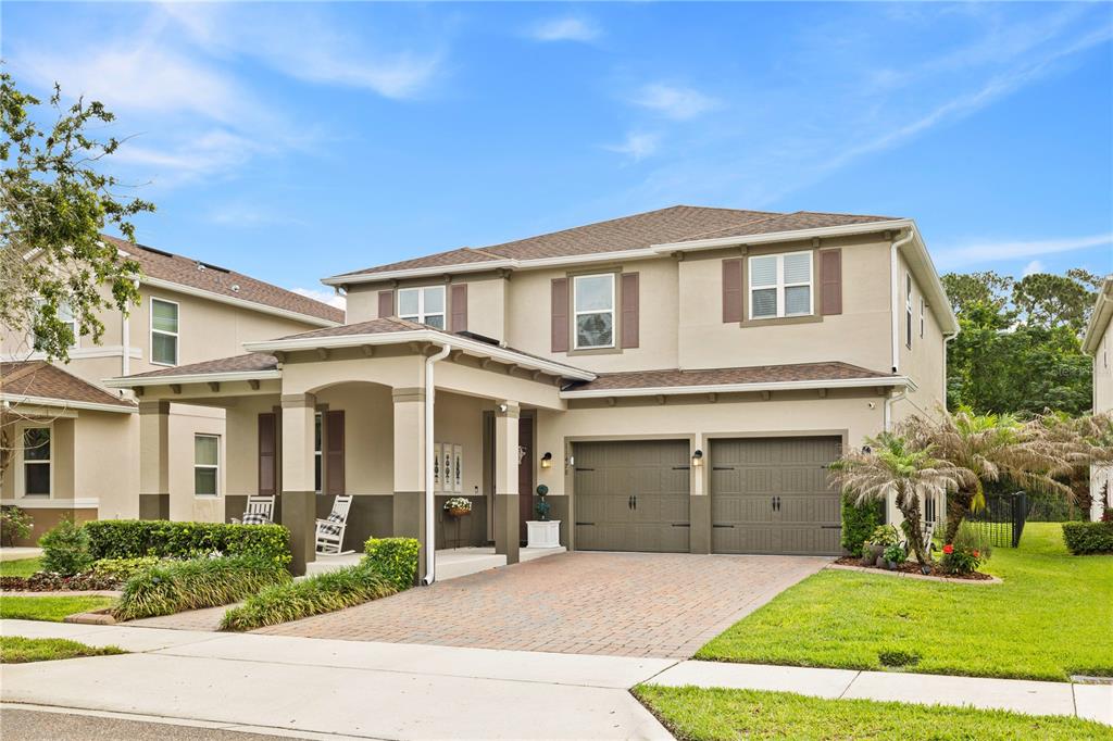 A two-story suburban house with a covered front porch and a two-car garage — 11478 WAKEWORTH STREET, ORLANDO, FL