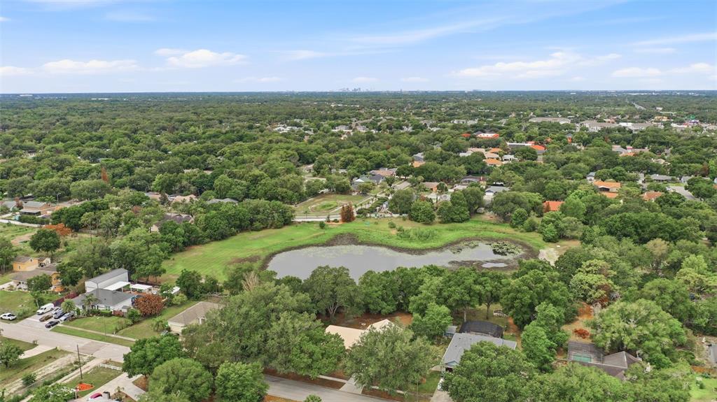 An aerial view shows a residential neighborhood surrounding a central pond with dense tree cover — 3286 LAKE TWYLO ROAD, ORLANDO, FL