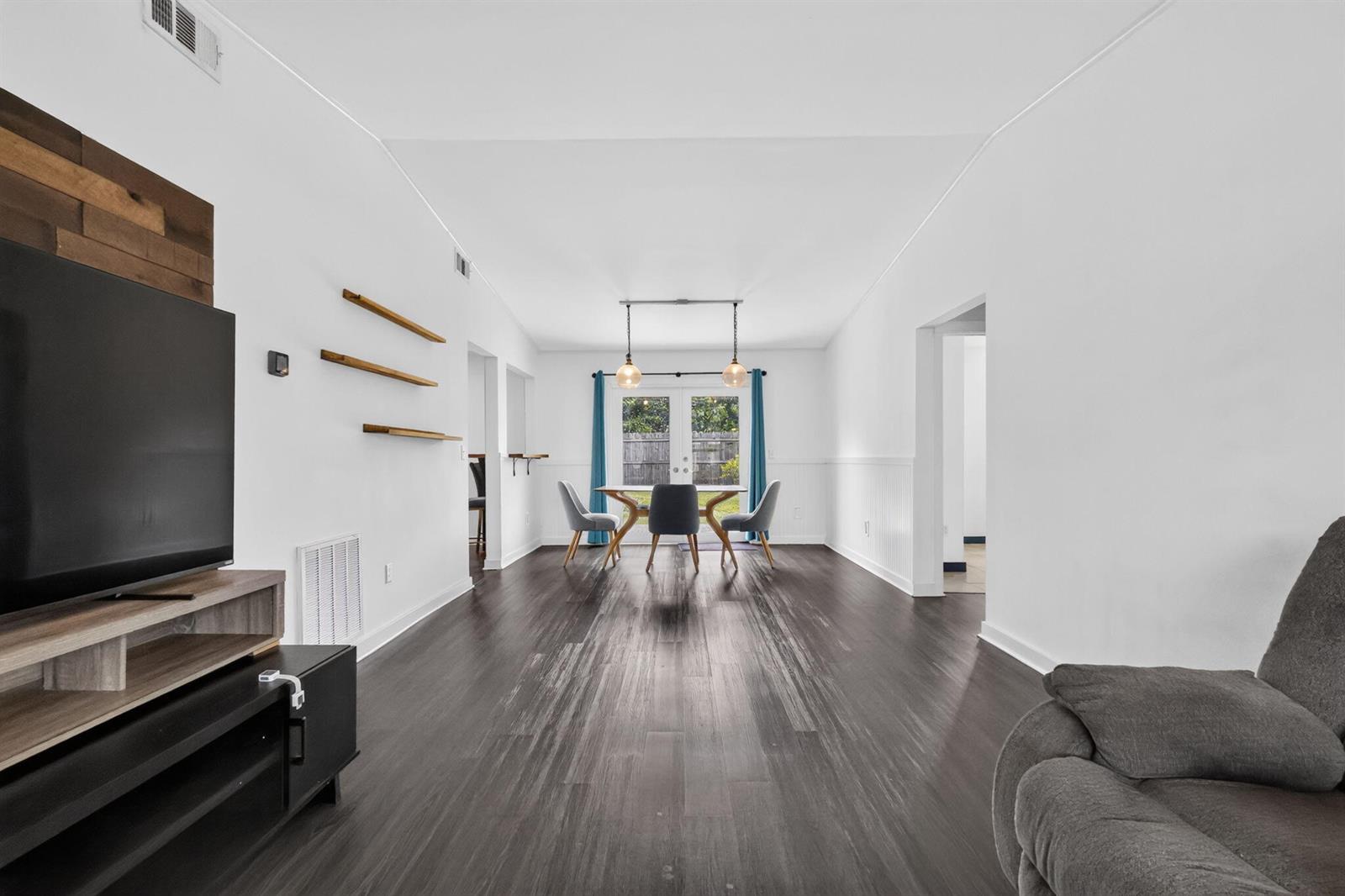 A living and dining area features dark wood-look flooring, white walls, and a glass door — 5258 Canal Circle W, Lake Worth FL 33467, LAKE WORTH, FL