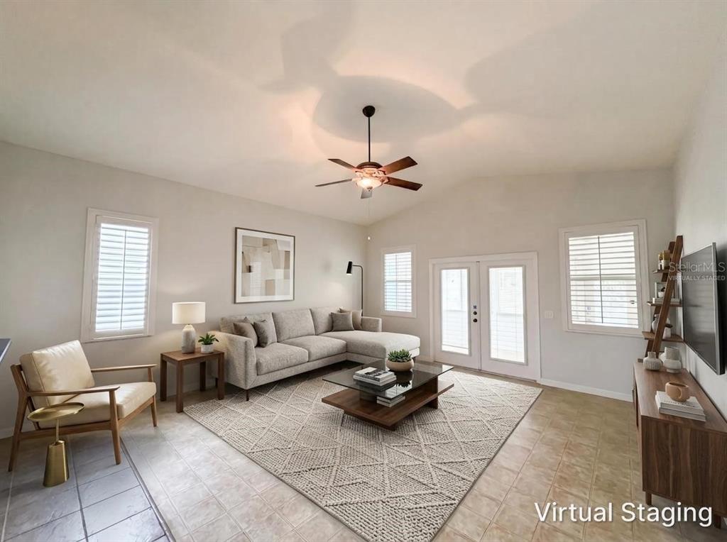 A virtually staged living room features a sectional sofa, area rug, and ceiling fan — 376 TRAVELERS DRIVE, POLK CITY, FL