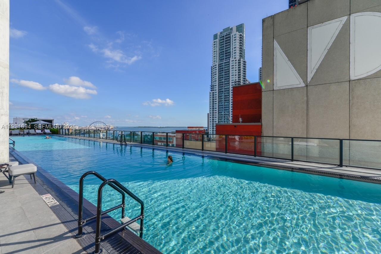 An outdoor rooftop swimming pool overlooks a city skyline and a body of water — 398 NE 5th St # 2407, Miami FL 33132, MIAMI, FL