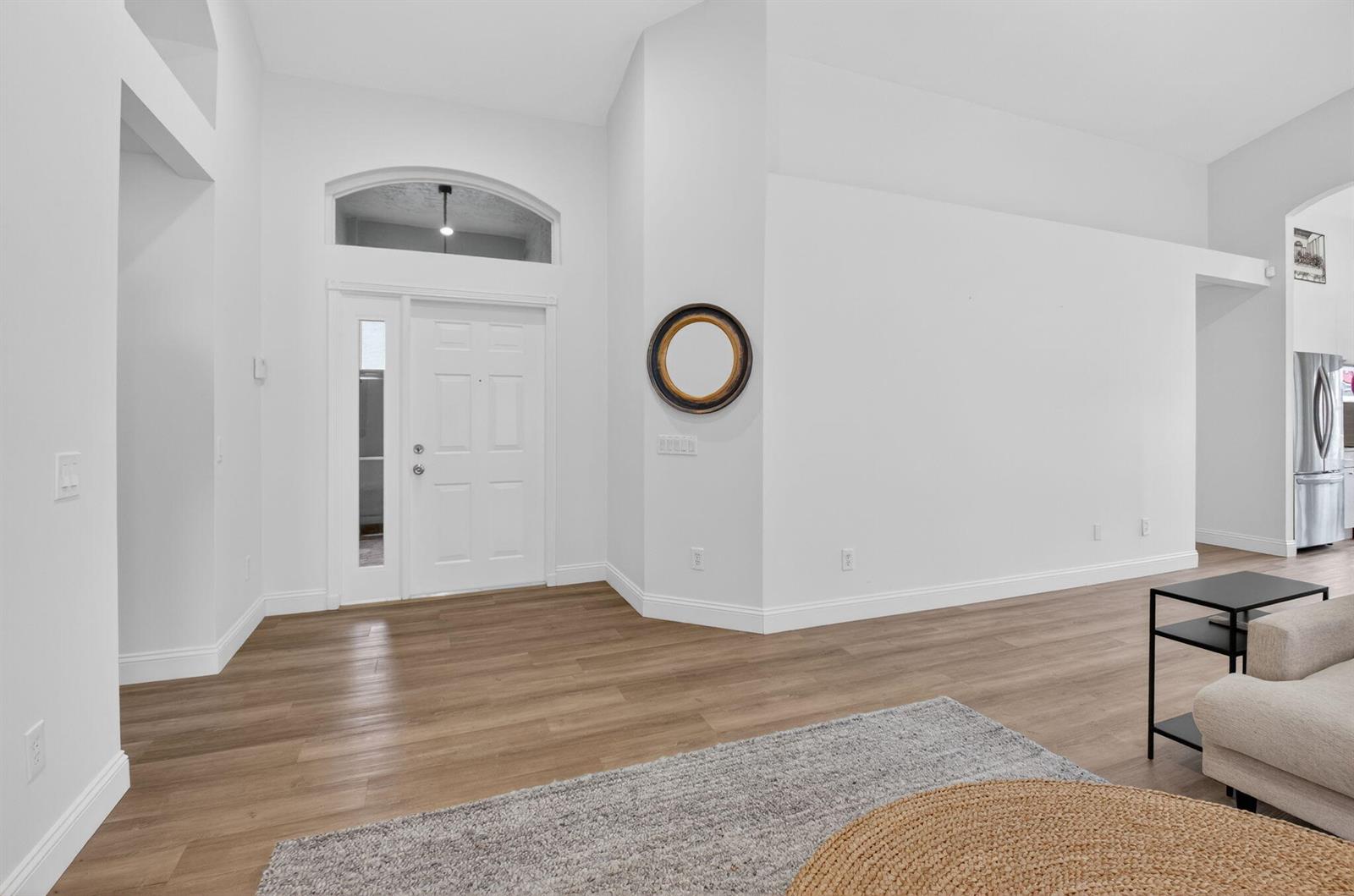 A bright entryway features white walls, light wood flooring, and a front door with sidelights — 7440 W Mercada Way, Delray Beach FL 33446, DELRAY BEACH, FL
