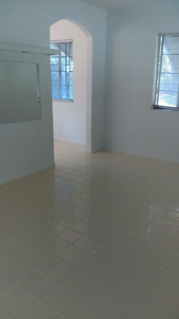 An empty room with white tiled floors, white walls, and an arched doorway — 11810 Ellison Wilson Road, FL 33408, FL