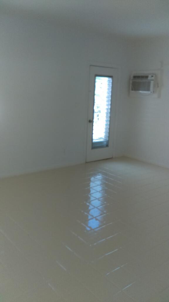 An empty room with white walls, light-colored tile flooring, a glass-paneled door, and an air conditioner — 11810 Ellison Wilson Road, FL 33408, FL