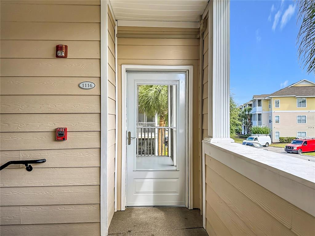 A beige exterior wall with a door, fire alarm, and unit number 1116 — 4802 51ST STREET W UNIT 1116, BRADENTON, FL