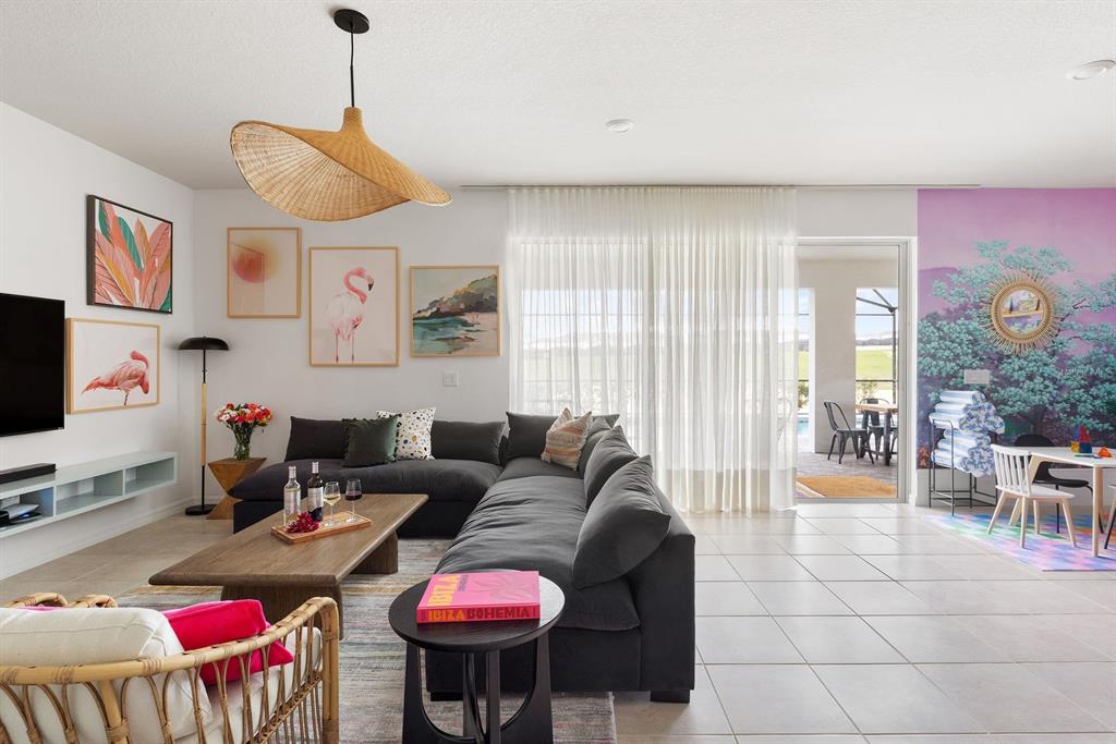 A living room with a gray sectional sofa, coffee table, and a large wall mural — 2320 LELANI CIRCLE, DAVENPORT, FL