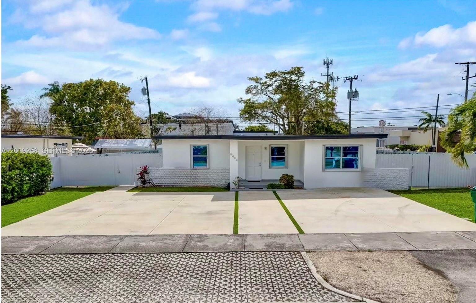A single-story white house with a flat roof and a large concrete driveway — 9494 SW 39th St, Miami FL 33165, MIAMI, FL
