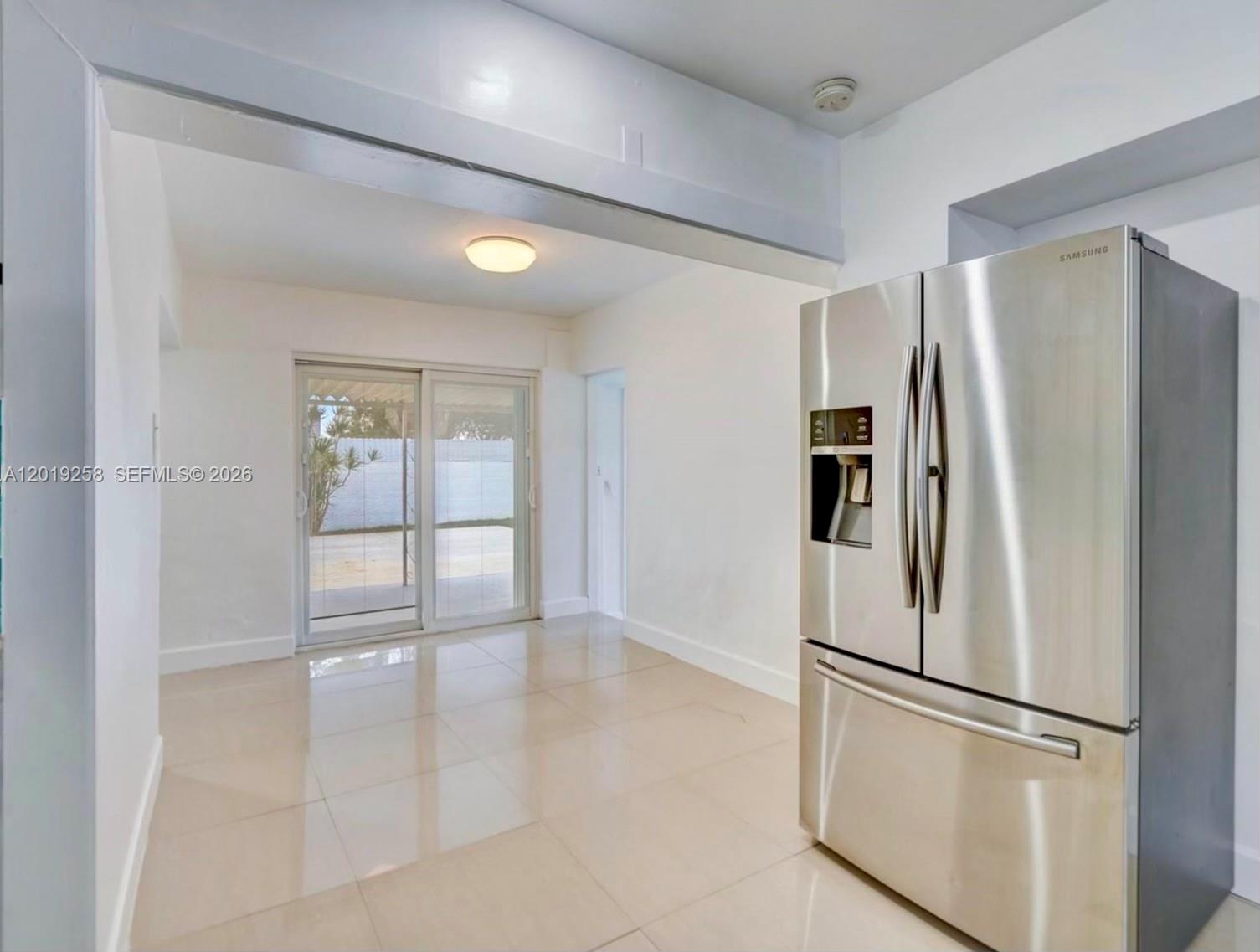 A kitchen area features light tile flooring, white walls, and a stainless steel Samsung refrigerator — 9494 SW 39th St, Miami FL 33165, MIAMI, FL