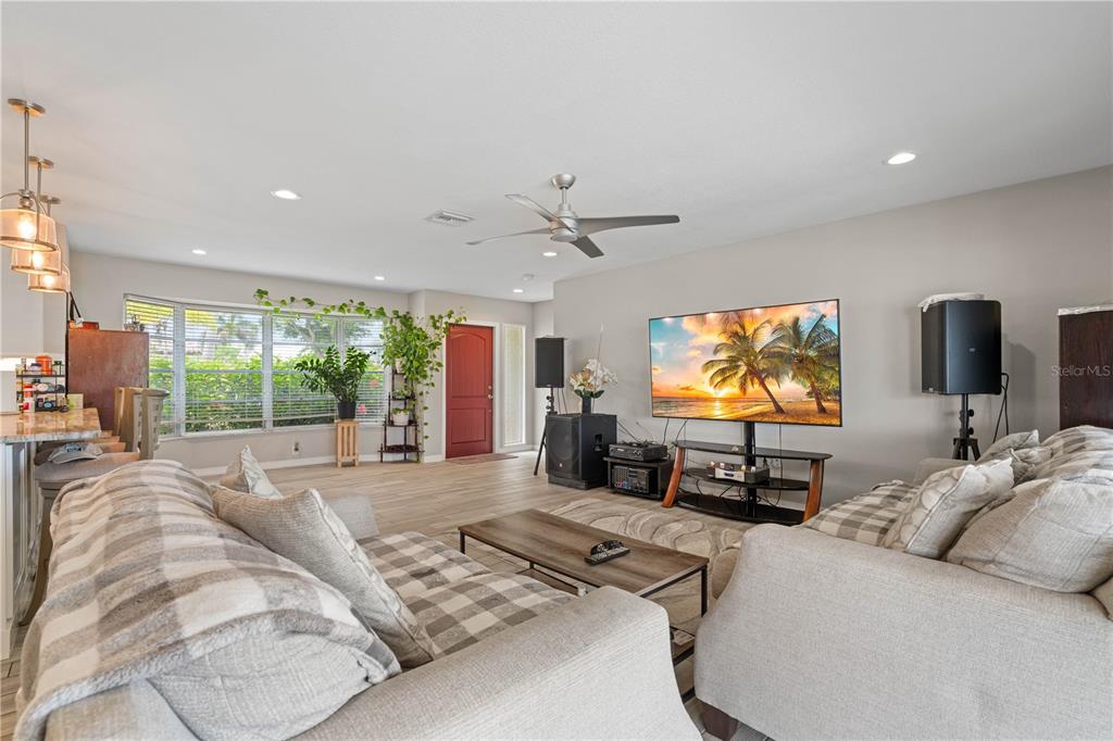 A living room features a television, two sofas, a ceiling fan, and a red door — 2208 CASSINO COURT, PUNTA GORDA, FL