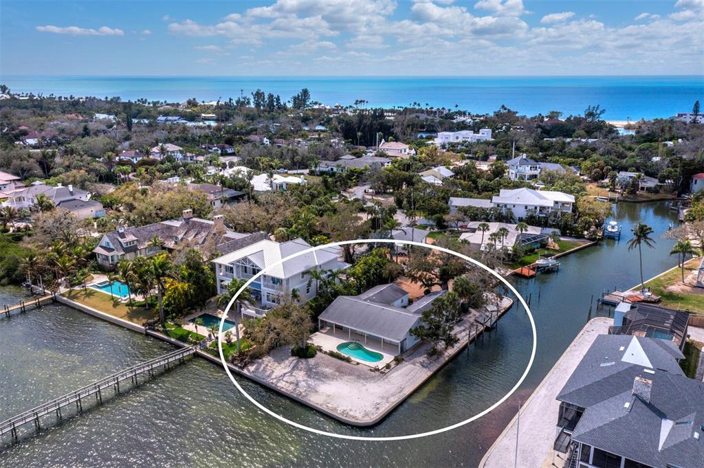 An aerial view shows a waterfront house with a pool on a corner lot — 1267 STARBOARD LANE, SARASOTA, FL
