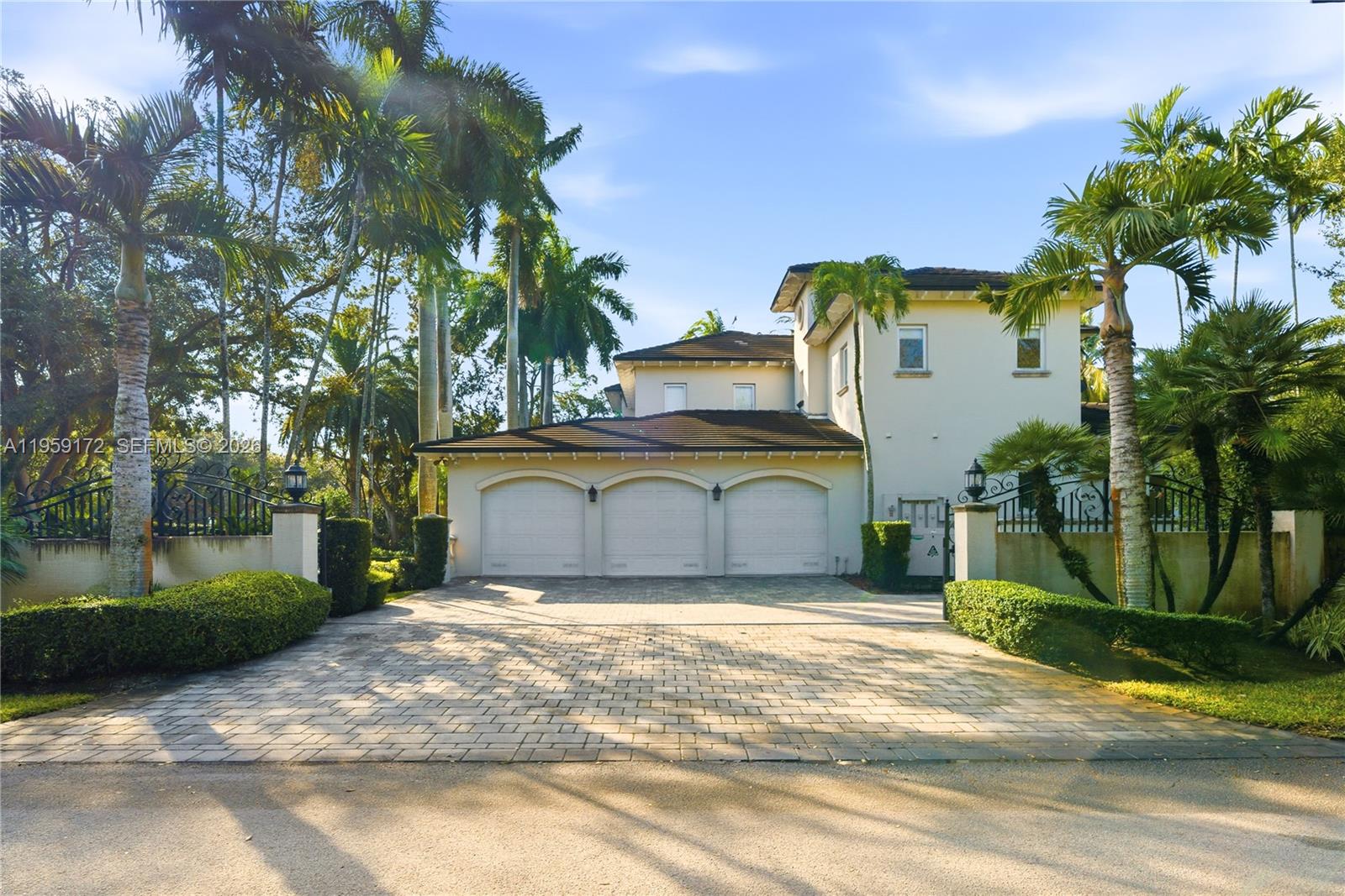 A three-car garage is attached to a two-story house with a paved driveway and palm trees — 8400 SW 52nd Ave, Miami FL 33143, MIAMI, FL