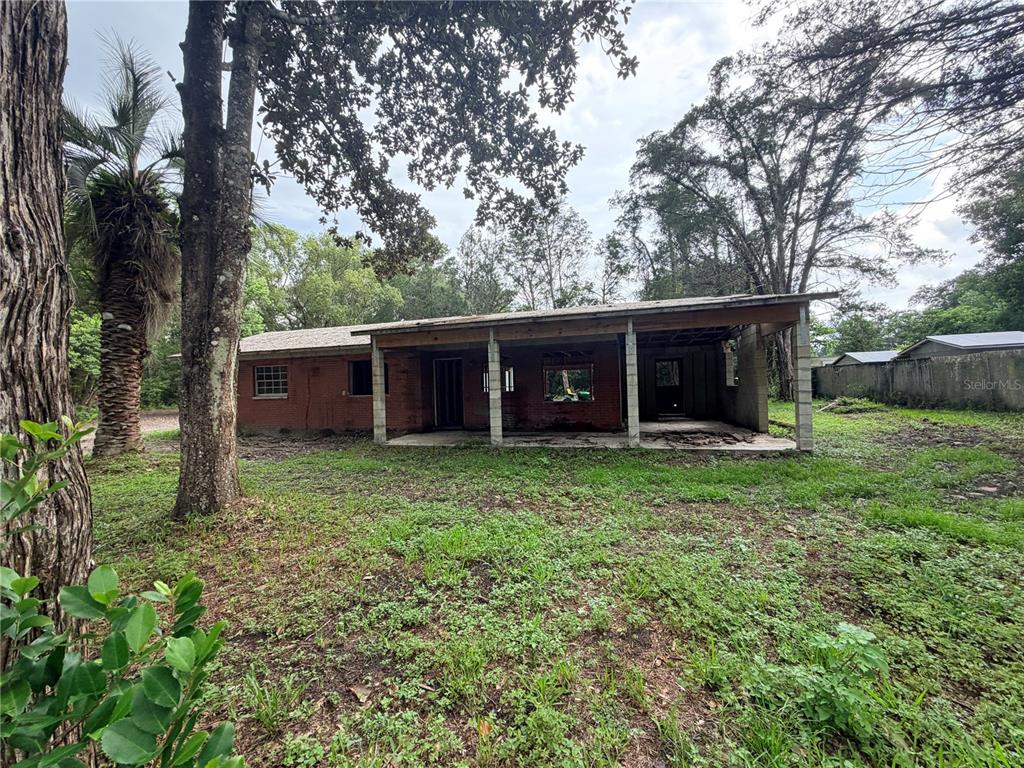 A single-story brick house with a covered porch sits on a grassy lot — 343 LINCOLN AVENUE, BROOKSVILLE, FL