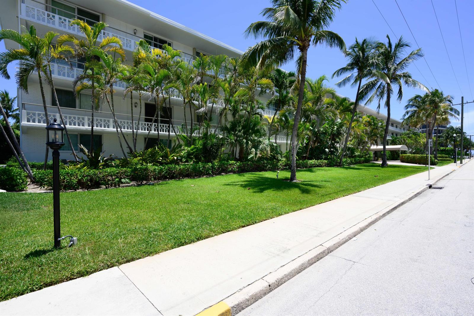 A multi-story white apartment building sits behind a manicured lawn and palm trees — 139 Sunrise Avenue # 102, Palm Beach FL 33480, PALM BEACH, FL