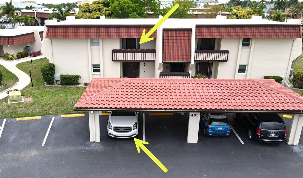 An exterior view of a two-story apartment building with a covered parking area in front — 311 GARVIN STREET UNIT 401C, PUNTA GORDA, FL