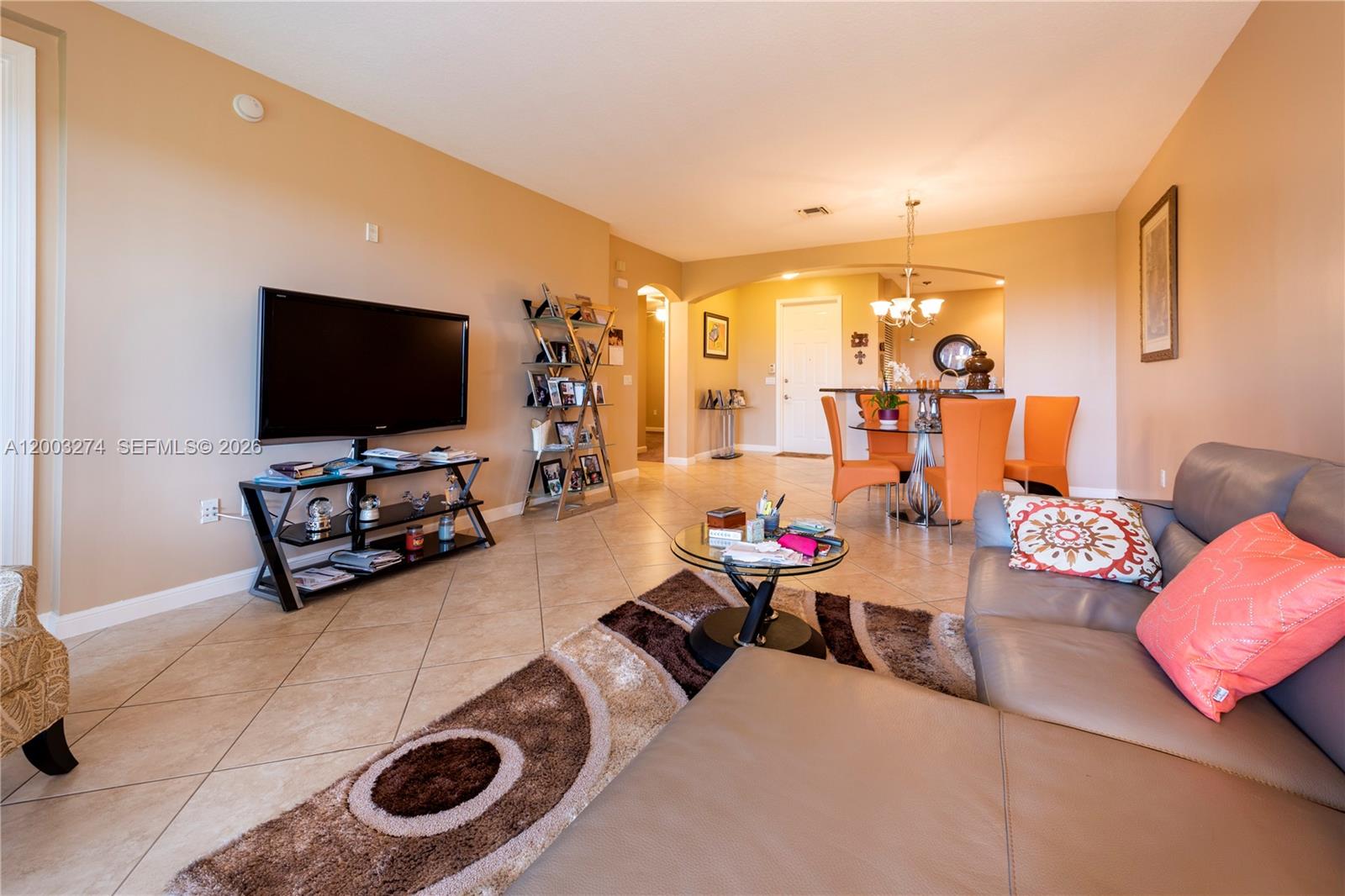A living room with tile floors, a television, a dining area, and a leather sofa — 3020 NW 125th Ave # 317, Sunrise FL 33323, SUNRISE, FL