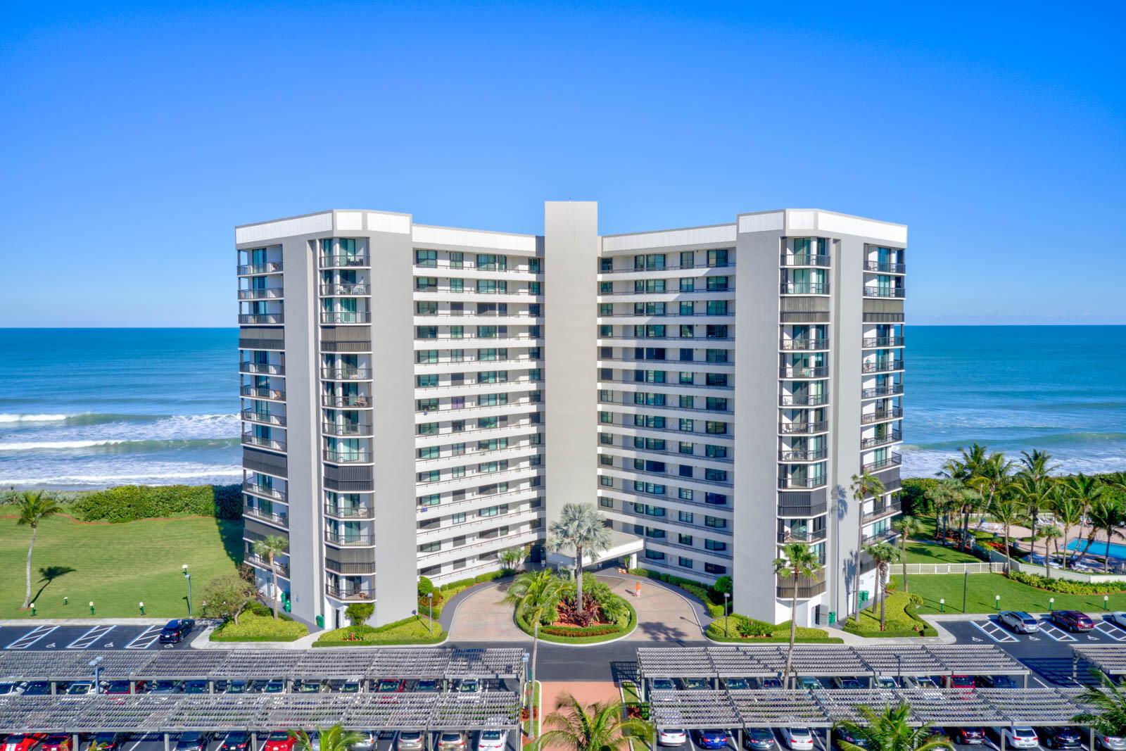 An aerial view of a multi-story beachfront condominium building with a parking lot in front — 8800 S Ocean Drive # 109, Jensen Beach FL 34957, JENSEN BEACH, FL