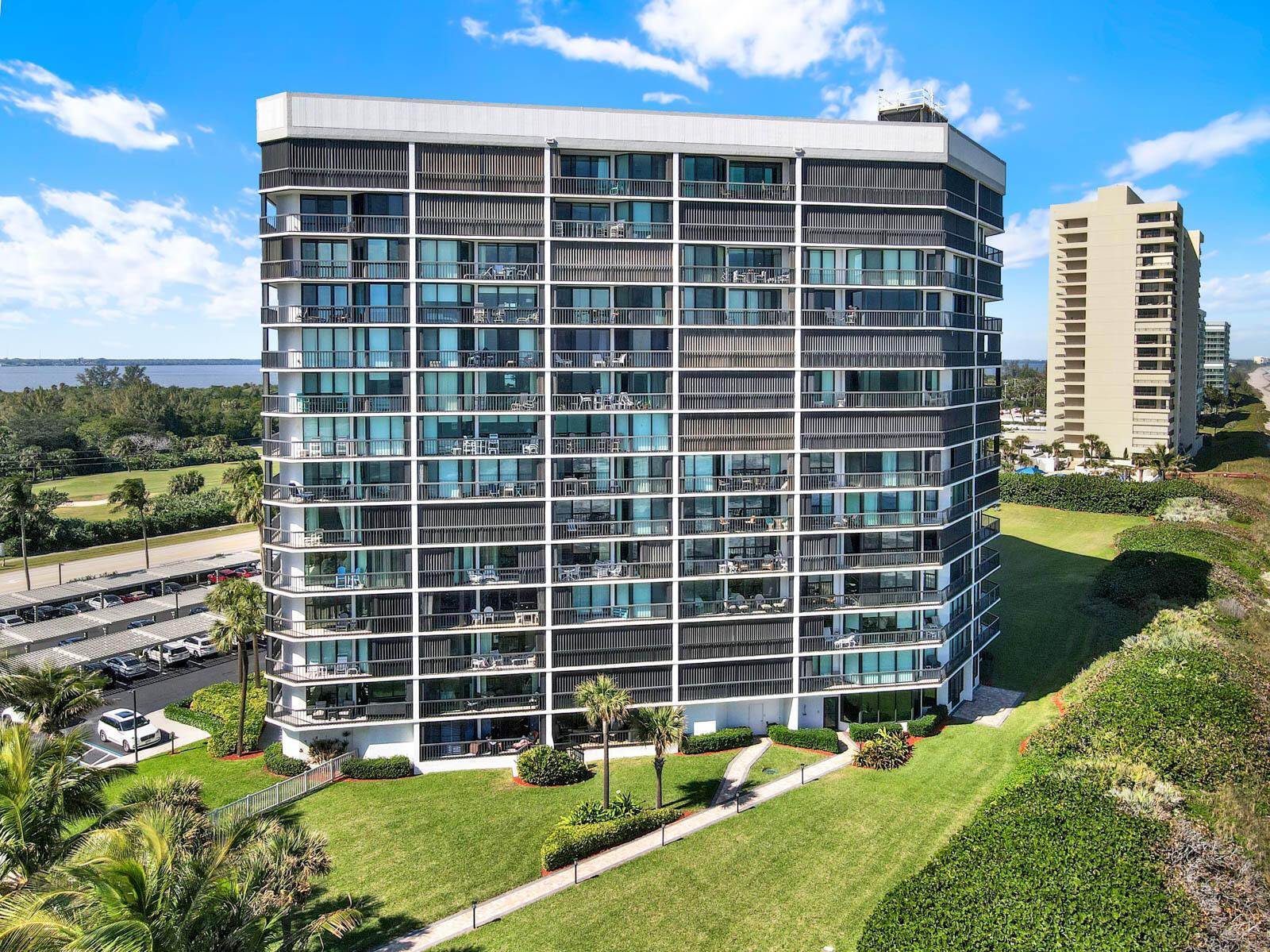 An exterior view of a multi-story residential building with balconies and a parking lot — 8800 S Ocean Drive # 109, Jensen Beach FL 34957, JENSEN BEACH, FL