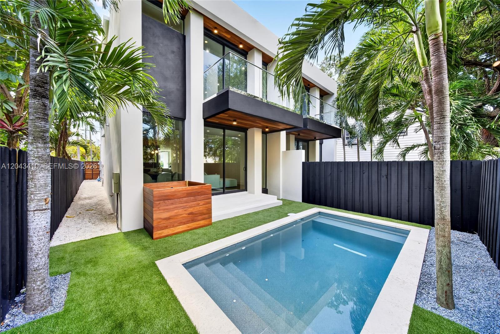 A modern two-story house features a small swimming pool, artificial turf, and a wooden planter — 1032 SW 11th Ave, Miami FL 33130, MIAMI, FL