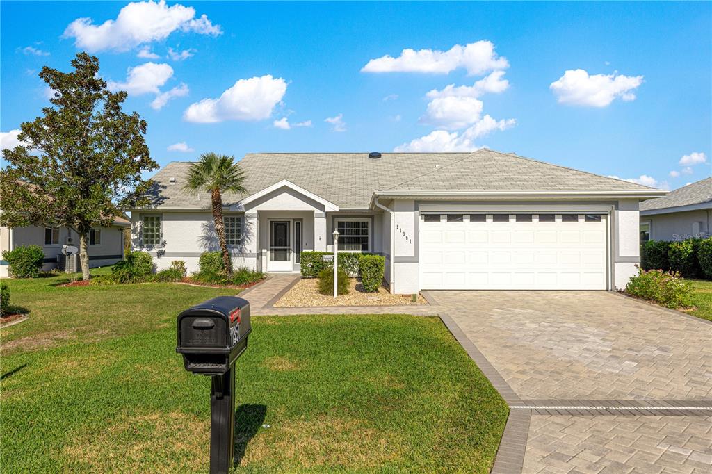 A single-story house with a white garage, paved driveway, and a front lawn — 11351 SE 175TH PLACE, SUMMERFIELD, FL