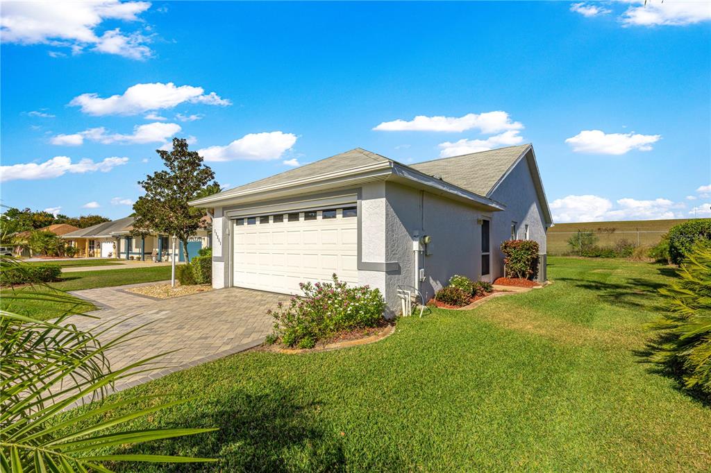 A single-story house with a white garage door, paved driveway, and a grassy side yard — 11351 SE 175TH PLACE, SUMMERFIELD, FL