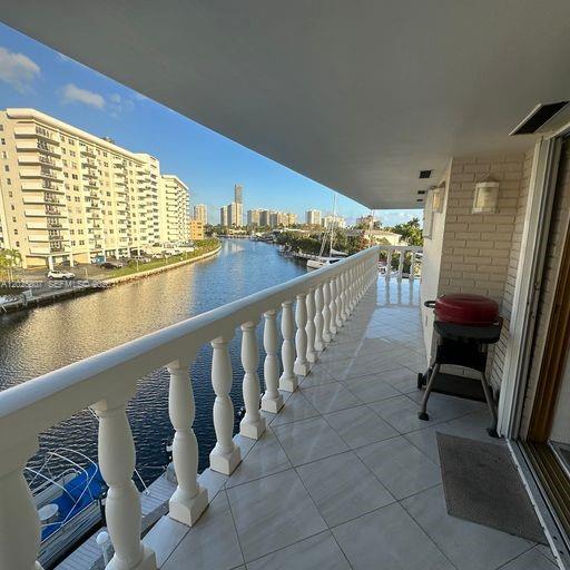 A balcony with a white balustrade overlooks a canal with high-rise buildings in the distance — HALLANDALE BEACH, FL