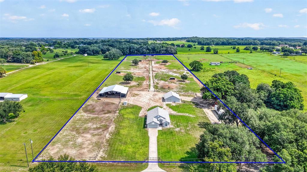 An aerial view shows a house and several outbuildings on a large, fenced rural property — 14125 SE 175TH STREET, WEIRSDALE, FL