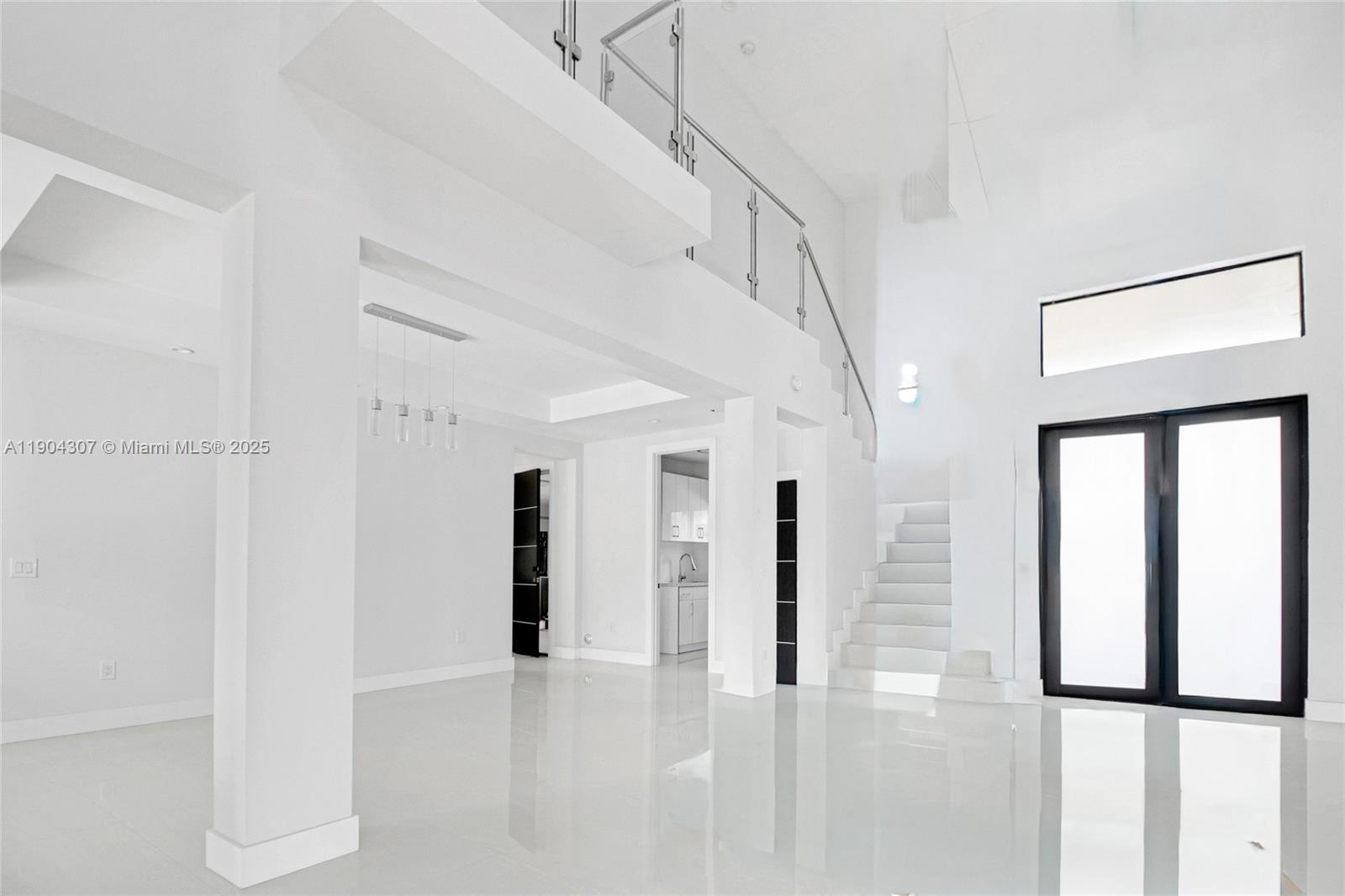 A bright, minimalist living space features white tile floors, a staircase, and high ceilings — 12890 NW 2nd St, Miami FL 33182, MIAMI, FL